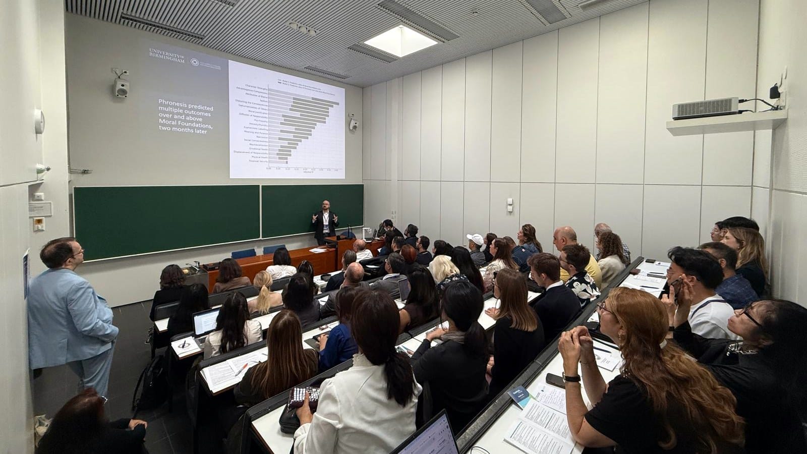 Shane McLoughlin presenting research on practical wisdom to a full lecture theatre
