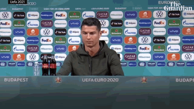 Cristiano Ronaldo moves Coca-Cola bottles aside and holds up water at a Euro 2020 press conference