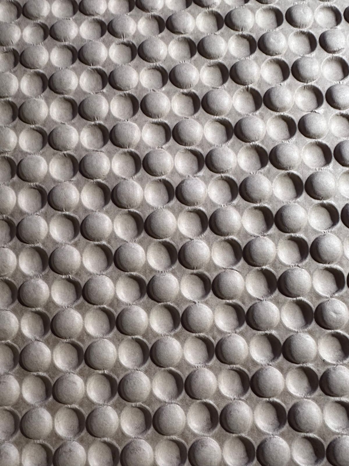 Dramatically lit embossed/debossed packing kraft paper that is almost like bubble wrap.