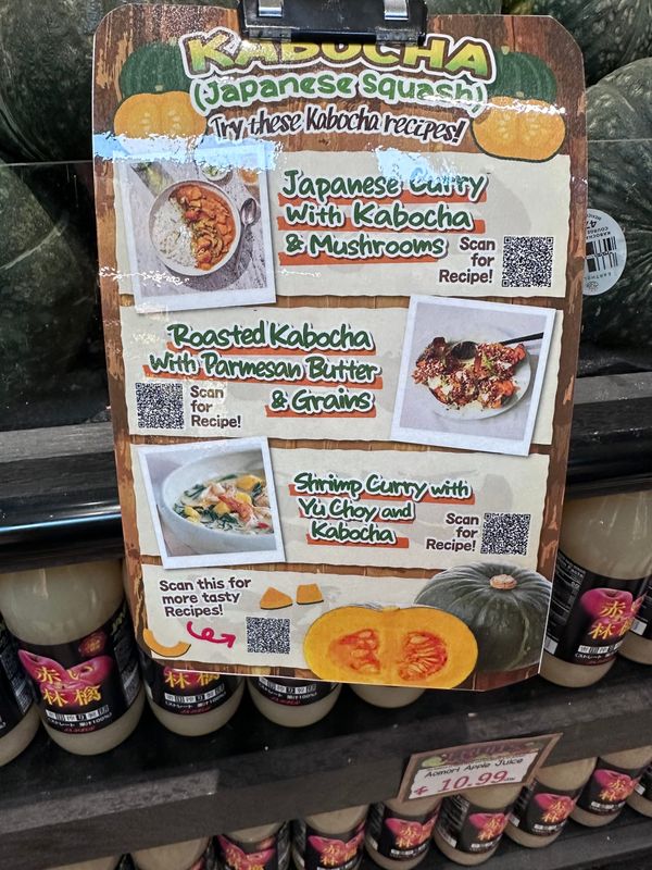 A laminated sign at Tokyo Central Market with recipe QR codes for several ways to make Kabocha.