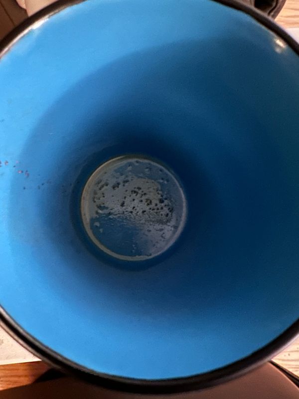 Long exposure into a blue-lined mug with a bit of tea dregs at the bottom.