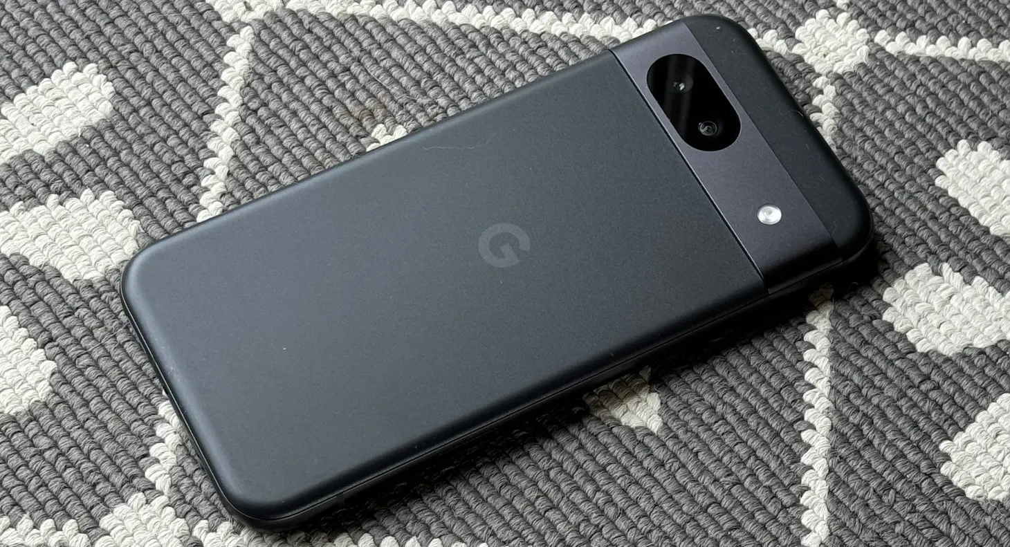 The black handset sits on a grey textured and patterned rug.