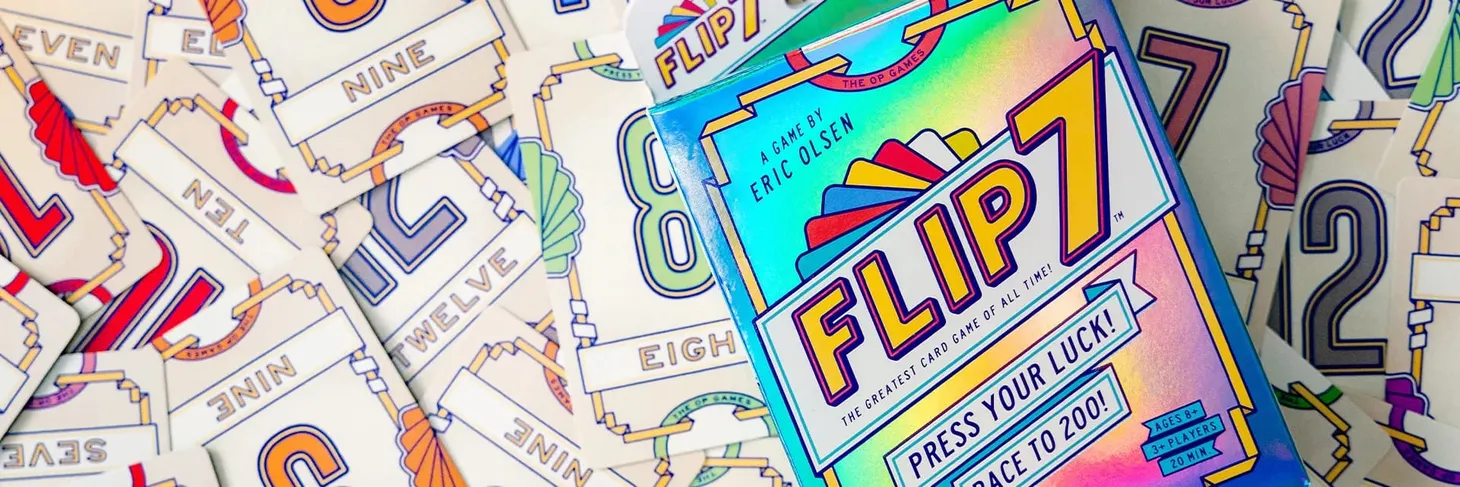 Flip7 cards are spread across a surface, with the Flip7 box sitting on top.
