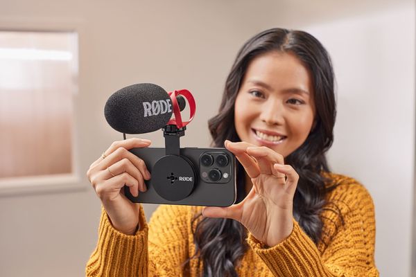 Women holds iPhone with Magnetic Mount and a microphone attached