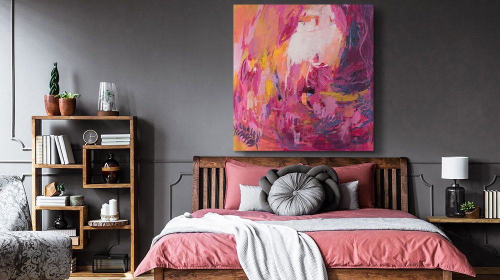 Cheerful pink and red abstract canvas print in a dark walled bedroom with pink accents