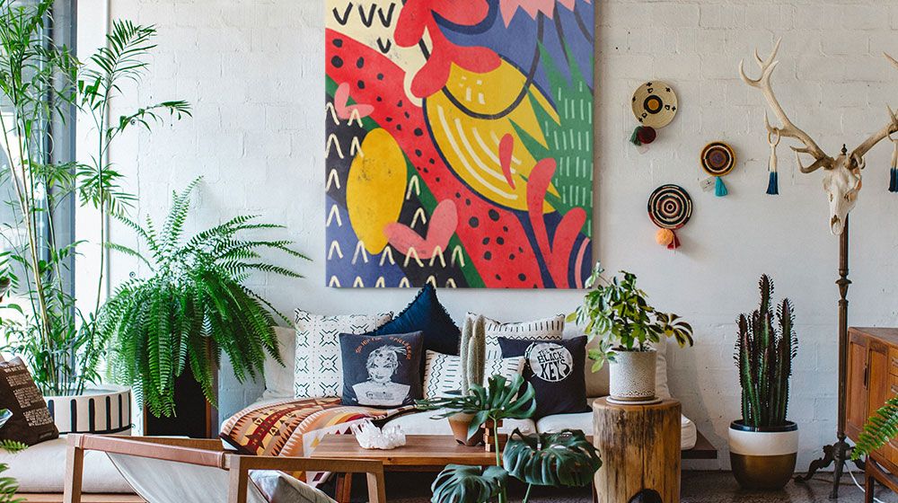 Vibrant Maximalism canvas wall art in a bright, plant-filled living room interior.