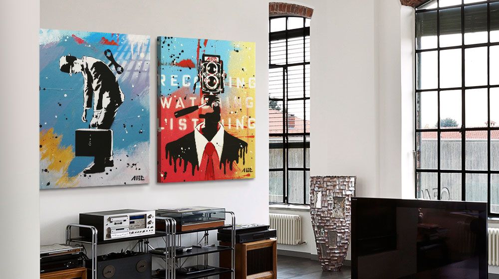 Two brightly colored canvas prints hung in a tall ceiling bright apartment