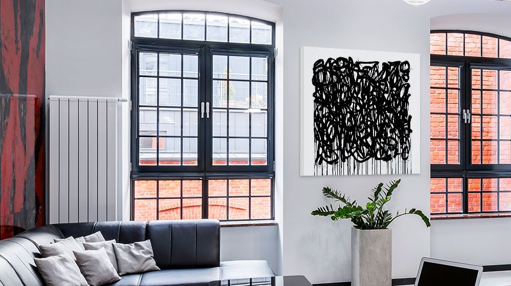 high contrast canvas print hung between two multi-paned windows that look out to a brick building