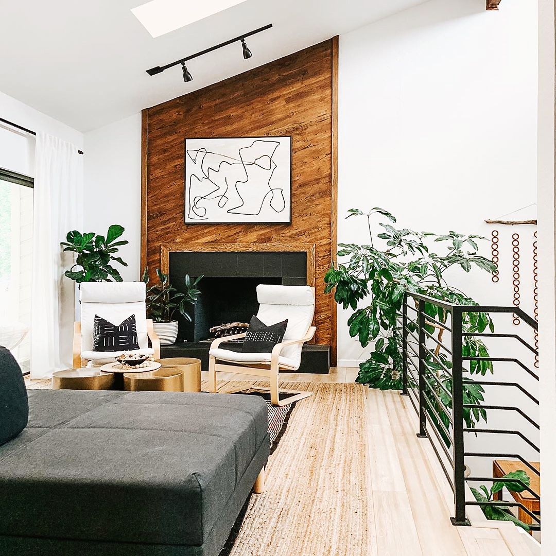 Bold line art canvas print in black floating frame over fireplace in contemporary living room.