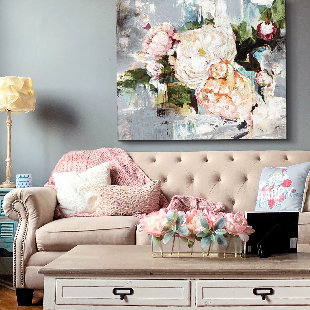 Pink and gray peony abstract painting above light pink couch with rustic wood table.