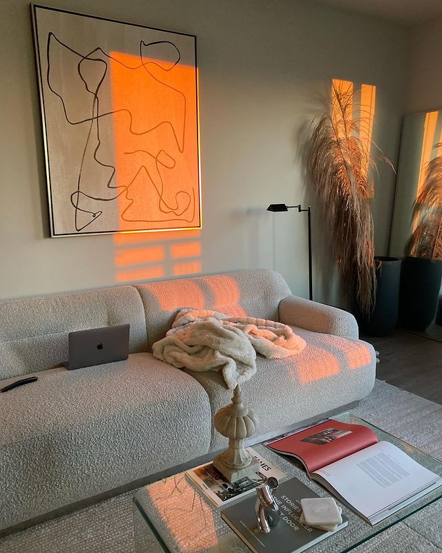 Bold line art canvas print in silver float frame in living room at sunset.