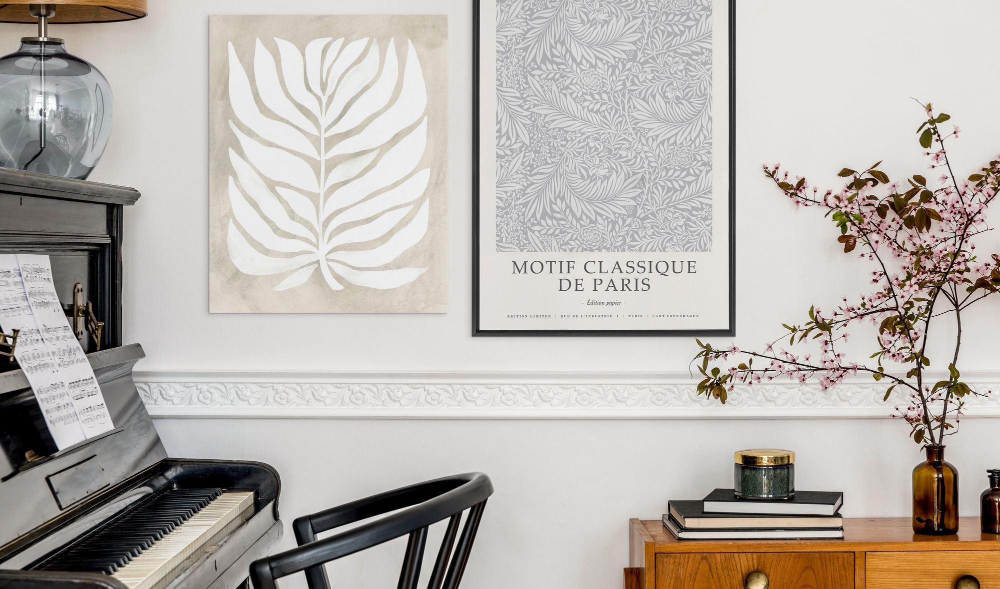 Two botanical inspired wall art prints on hanging beside a piano