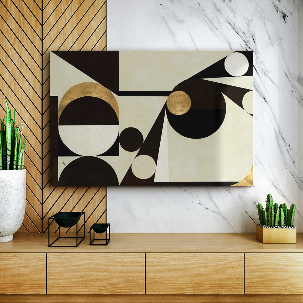 Black, gold, and neutral-toned geometic canvas art above a light brown colored dresser.