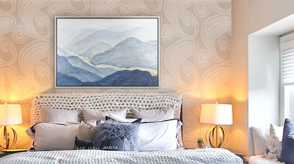 Blue Mountains Wall Art by Patricia Pinto mounted in a floating frame, hung on a wall above a bed