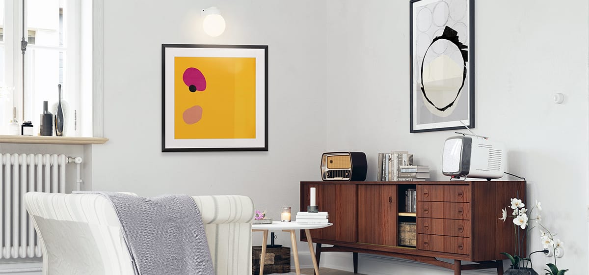 Framed wall art pieces in a living room setting with a light, muted color palette.