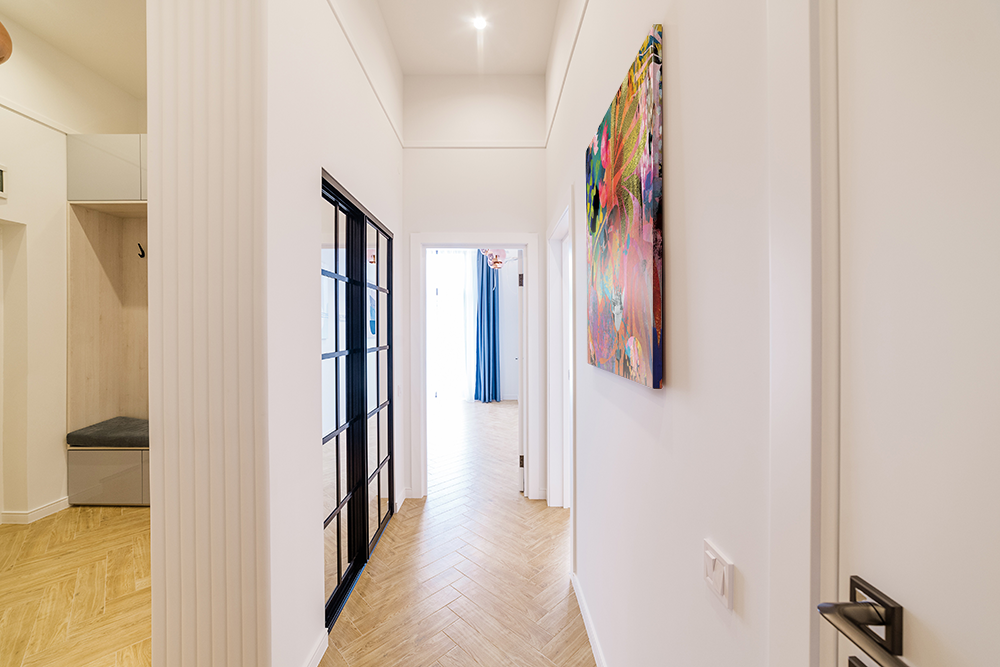 Modern hallway with a minimalist design and vibrant abstract wall art.
