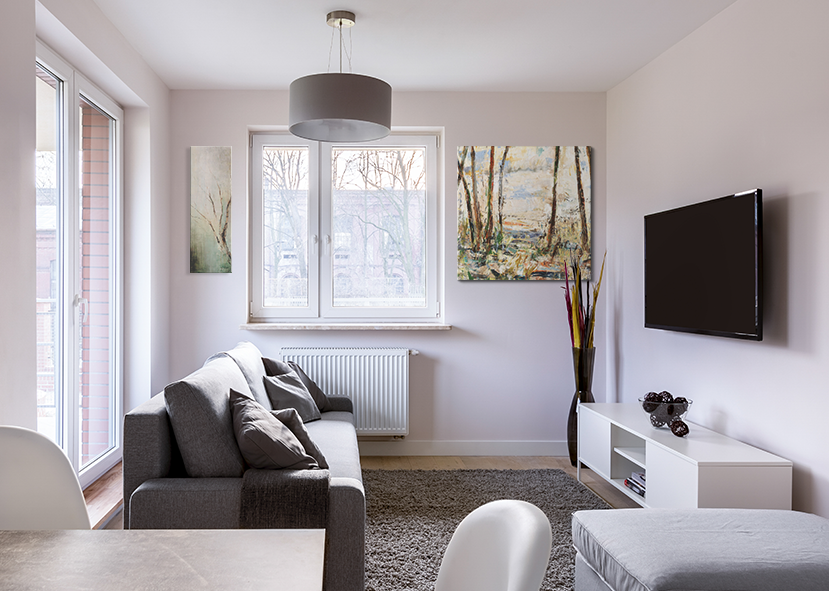 Contemporary living room with a minimalist design and nature-inspired wall art.