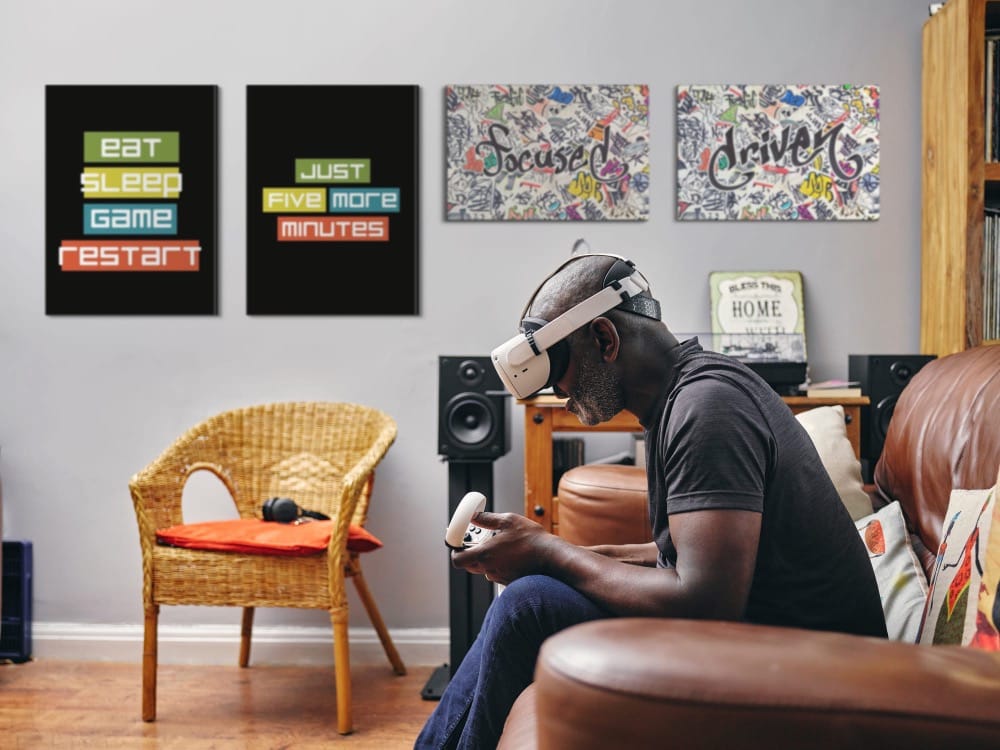 A man playing a virtual reality game in a room with gaming-themed wall art.