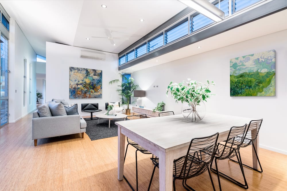 Open minimalistic living and dining area with abstract wall art.