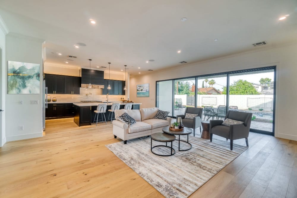 Open-concept living room and kitchen with abstract and coastal wall art.