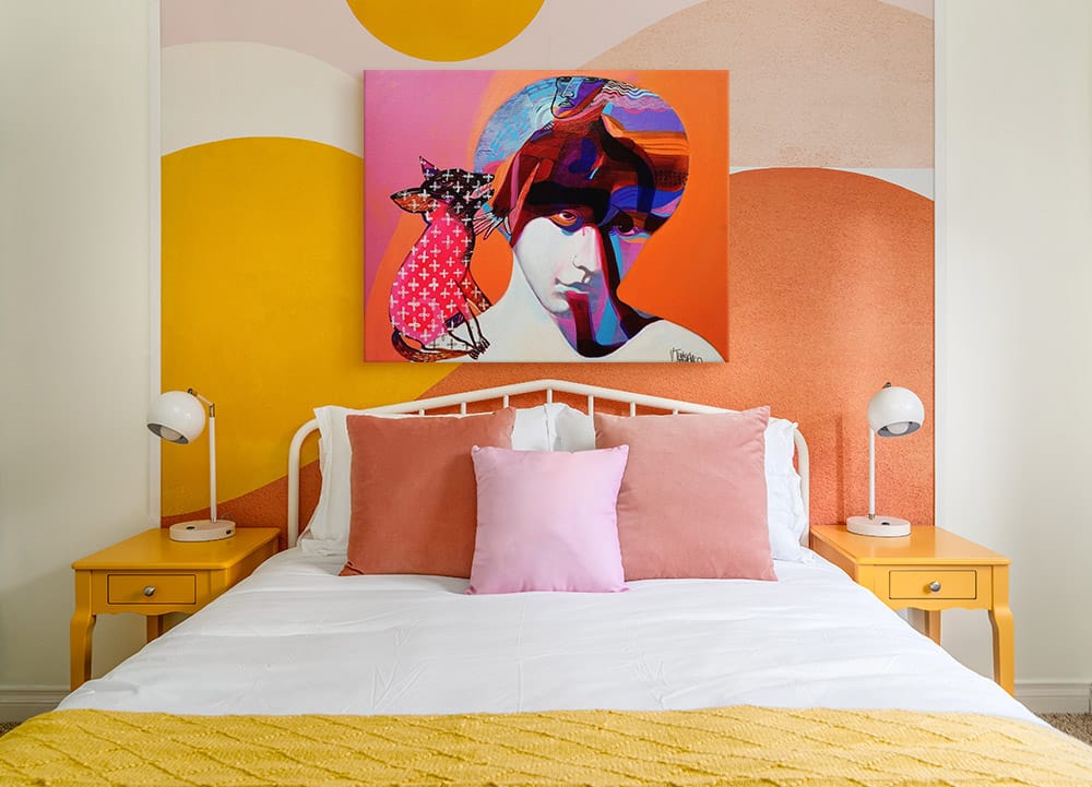 Bright modern portrait canvas art in an orange and yellow colorful bedroom