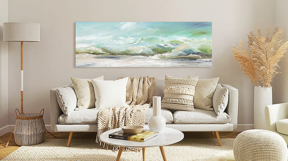 Oversized ocean landscape wall art centered above a sofa creating a focal point in a calm neutral living room
