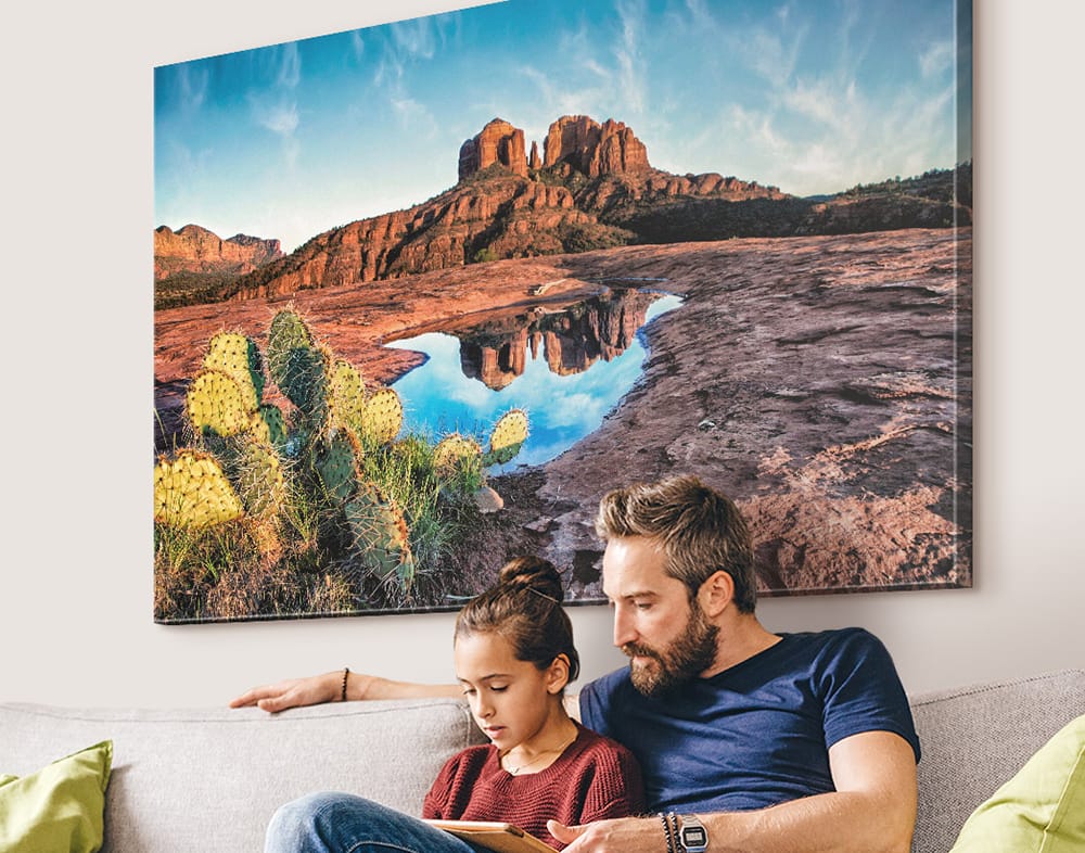 Large landscape canvas wall art displayed above couch, showing vibrant color, depth, and impact of quality canvas art prints in a home