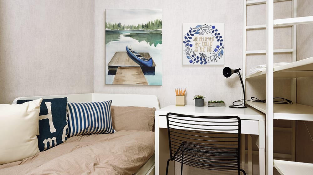 Minimal dorm room setup with wall art above desk and bed, highlighting how to use art to define study and relaxation areas