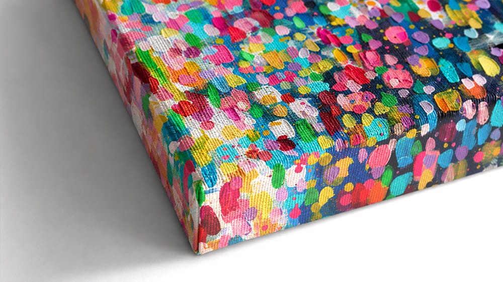 Close-up of a expertly folded corner of textured artist-grade canvas material wrapped around solid wood frame.