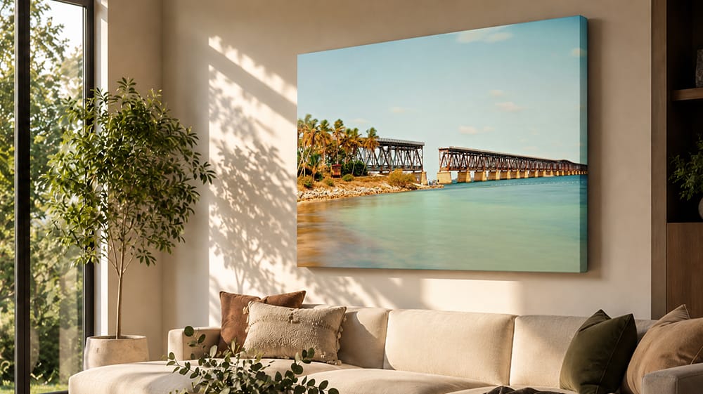 Large coastal bridge canvas art above a sofa in a sunlit living room