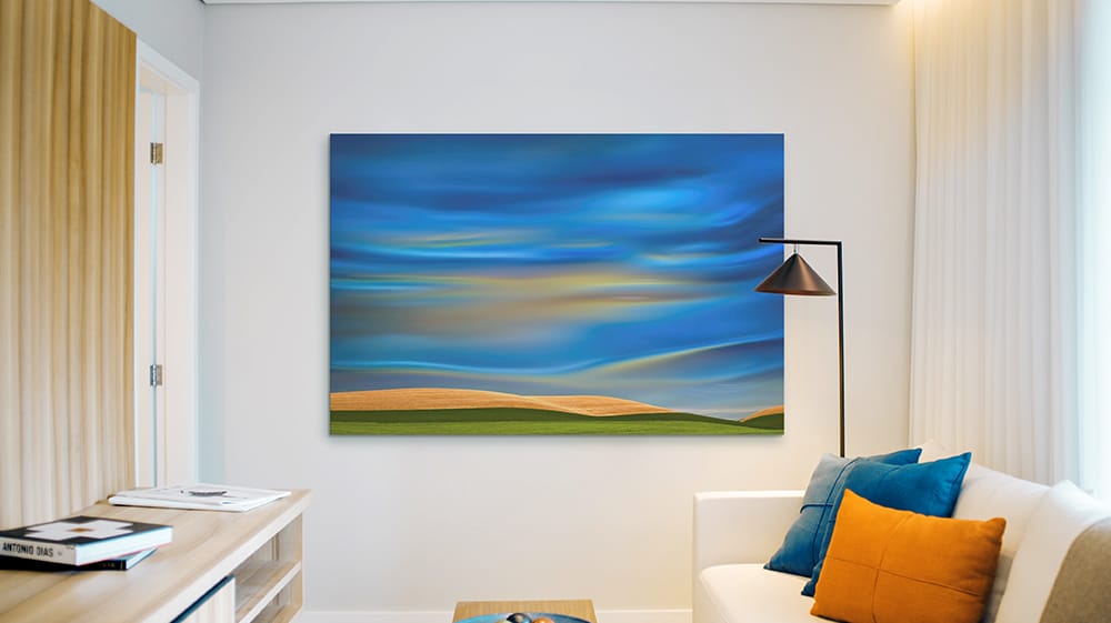 Large blue abstract landscape canvas in modern living room, illustrating the serene and layered look of cornflower blue wall art