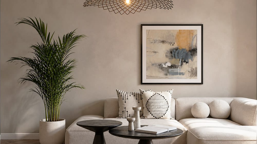 Neutral modern living room with framed abstract wall art above a sectional showing how softer artwork can add warmth and texture