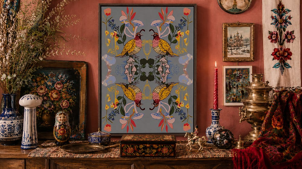 Ornamental global maximalist vignette layering decorative wall art with ceramics, floral motifs, metallic objects and richly patterned textiles.