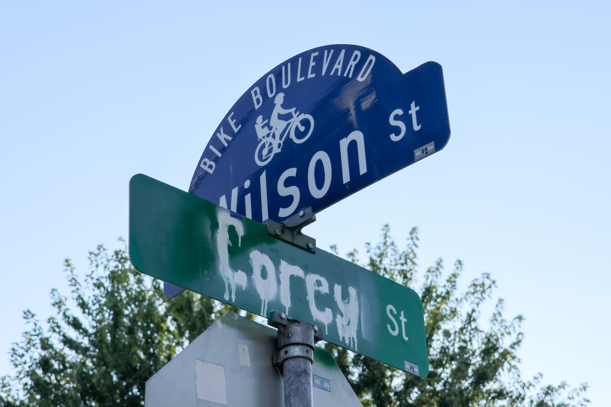 A green street sign has been painted over and replaced with "Corey St."