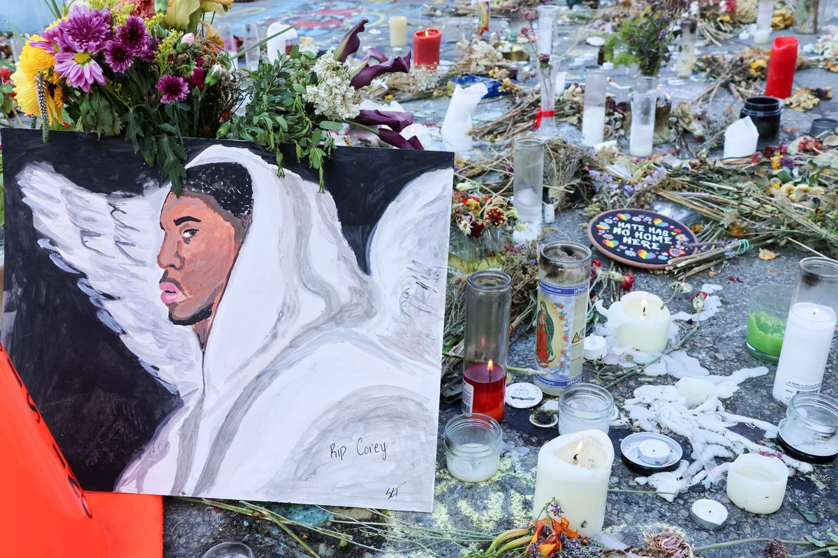 A hand-painted image of a Black man in white robes with angel wings is placed at the memorial to Corey Ruiz in Madison. It's surrounded by candles and flowers.