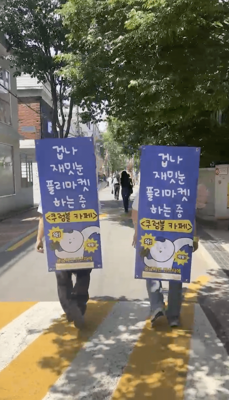 X배너 길거리를 플리마켓 홍보하는 멤버들