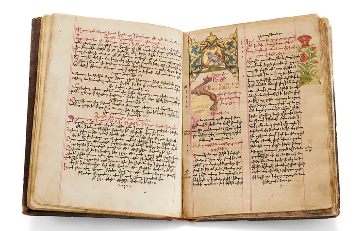 A book with Armenian language text in black and red ink, with four-color illustrations. The pages are browned with age. The cover is brown leather.