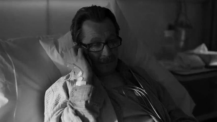 Commissioner Jim Gordon in his hospital bed talking to Detective Blake via mobile telephone.