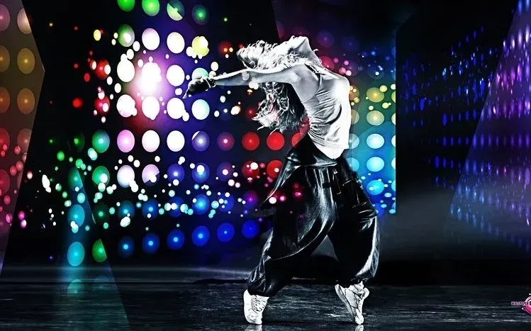 Women performing hip-hop dance moves in styled outfits with added graphics.