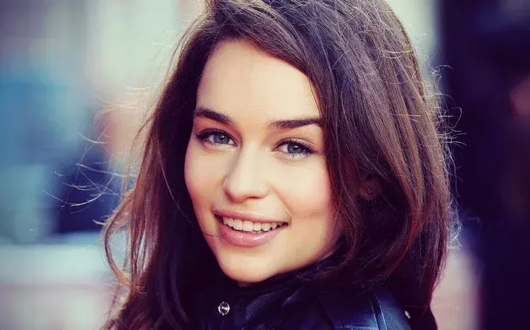Emilia Clarke in varied poses, colorful dresses, and hairstyles against scenic backgrounds.