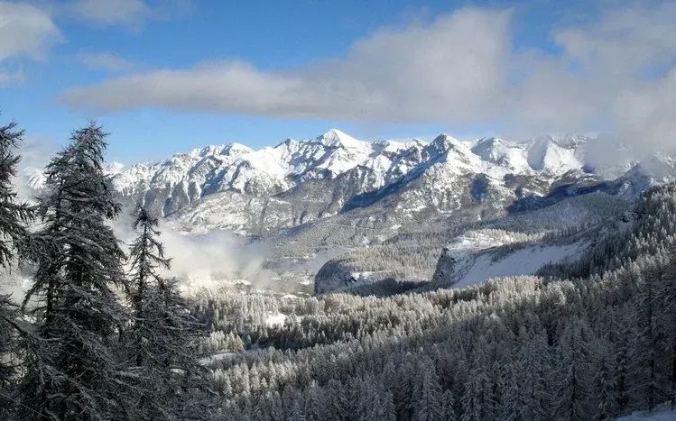Mountain scenery with mountains in the background and a body of water across the middle.