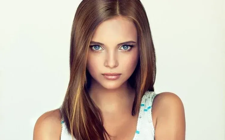 Female subject with long brown hair, grey eyes, pink lipstick, high cheekbones, and dark lashes.