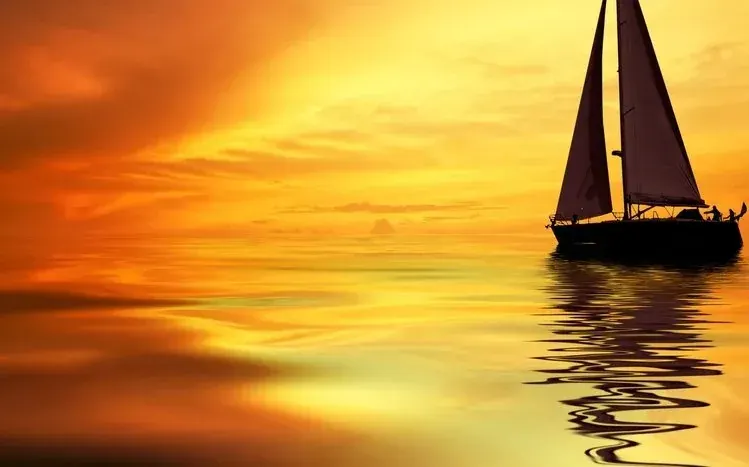 Sailing boats on water with clouds, sunlight, seashores, and buildings in the surrounding scenery.