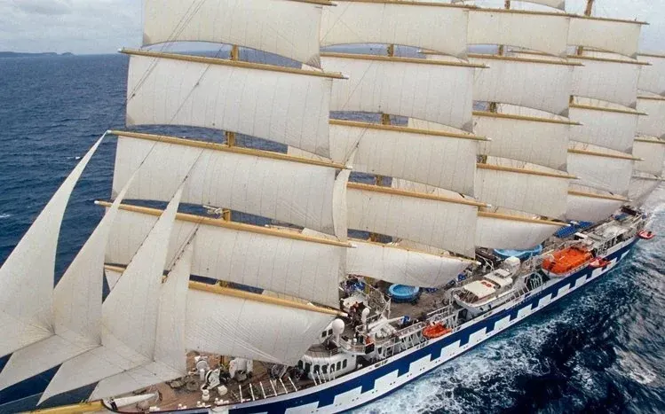 Large ships at sea, with masts, bowsprits, and ocean waves.