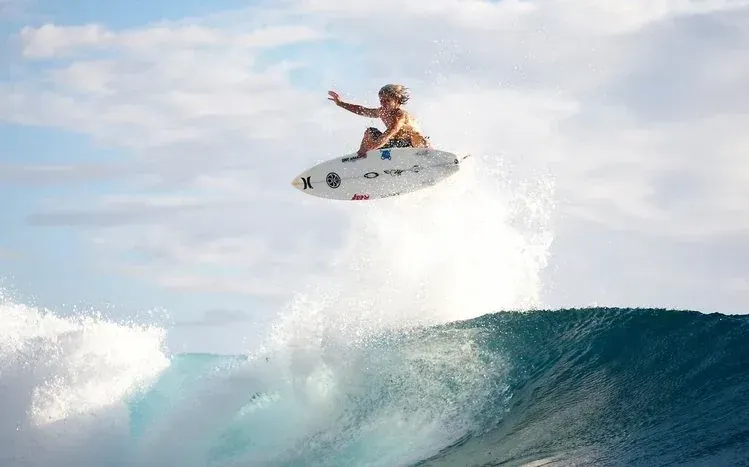 Female surfers riding ocean waves in a 30-wallpaper collection.