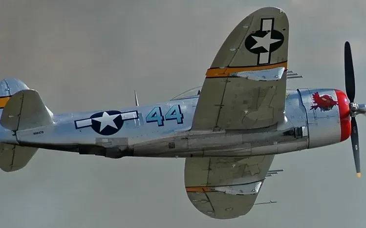 Paintings of World War II fighters, transport planes, and bombers flying over land.