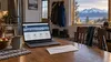 Alaskan household table with a plain envelope and laptop near a mountain window