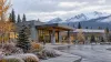 A modern Alaska community health clinic beneath mountains in cool early-autumn weather.