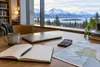 Conceptual Alaska college-planning desk with notebook, calculator and mountain view