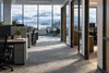 Conceptual editorial image of an unoccupied Alaska government office with mountains visible through the windows